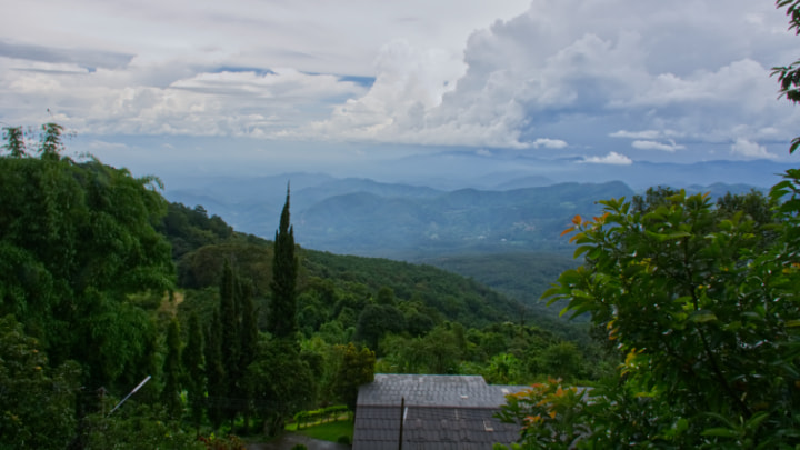 180 degree view from the "Doi Pui" cafe with stunning clear cloud and mountains surrounded by trees and people