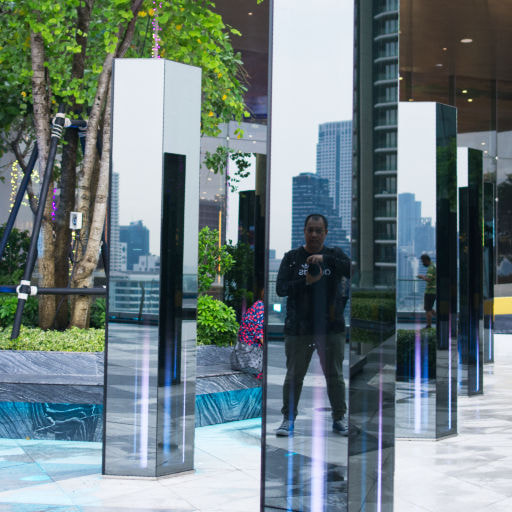 A man taking a photo of him relfecting on the crystal clear light bar located in Iconsiam shopping mall