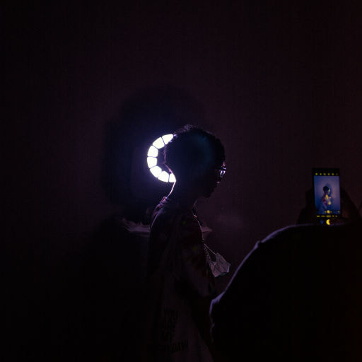 A man taking a photo of his friend in the front of light source for art photography